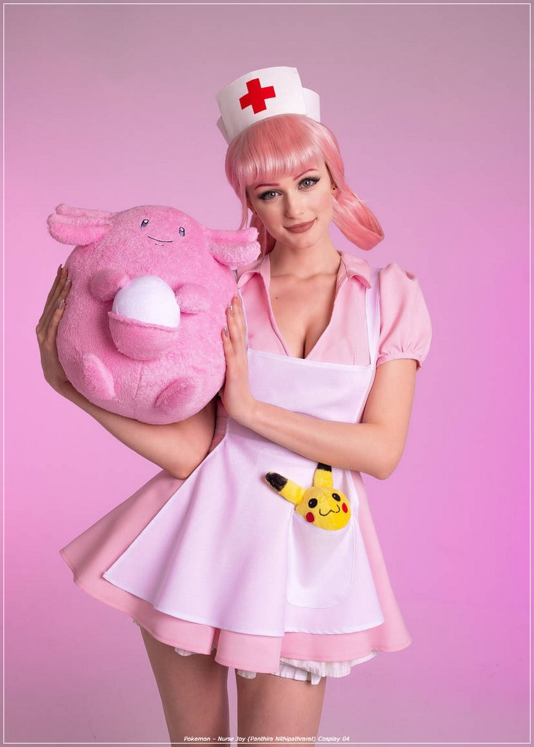 A woman dressed as Nurse Joy from Pokémon, wearing a pink dress and cap, holding a large plush toy of Chansey. The background is a soft pink.