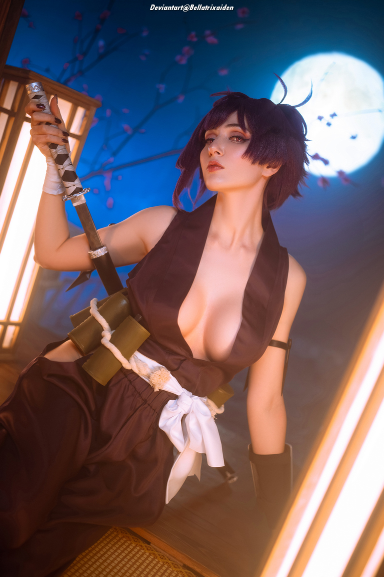 A person dressed in a dark kimono-style outfit poses with a katana, illuminated by soft lighting and a blue background featuring cherry blossom branches and a full moon.