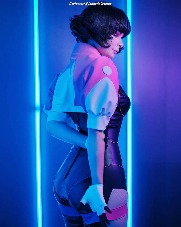 A person in a colorful cosplay outfit poses against a backdrop of blue neon lights, showcasing the back view and highlighting the details of the costume.