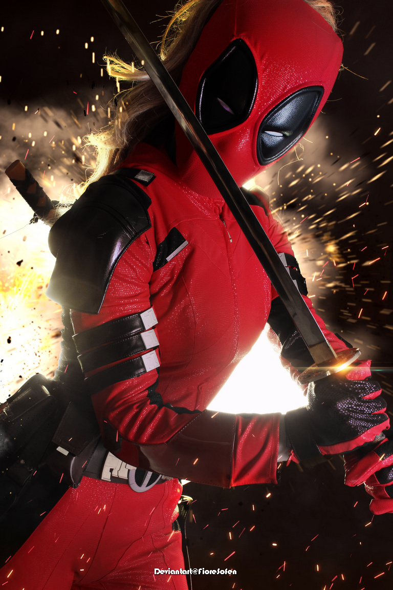 A warrior in a bright red costume with a black mask and sword, surrounded by explosive sparks.