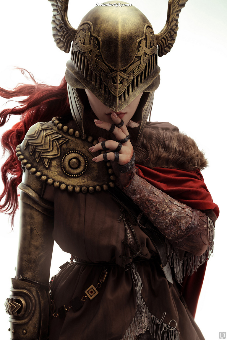 A warrior wearing an intricately designed helmet and armor, with long red hair flowing. The warrior holds a finger to their lips in a gesture of silence, set against a light background.