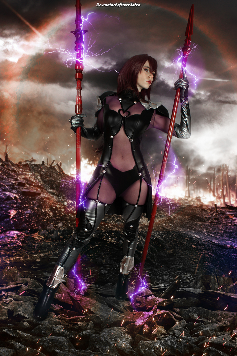 A female cosplayer dressed in a dark, form-fitting outfit with metallic elements, holding two red spears glowing with purple energy. The background features a dramatic, stormy landscape with lightning and a rocky terrain.