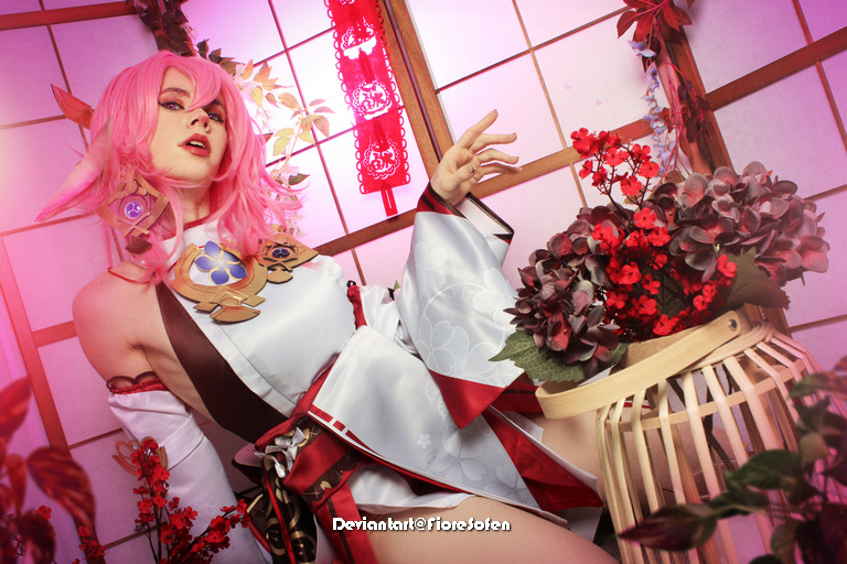 A character with pink hair and pointed ears poses elegantly in a traditional Japanese-inspired outfit, surrounded by vibrant flowers in a decorative basket.