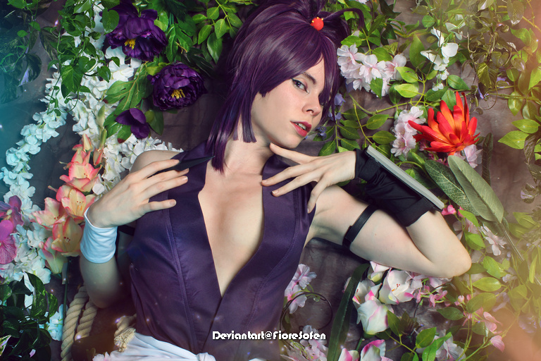 A character with purple hair posing among colorful flowers, wearing a dark outfit, showcasing a confident expression.