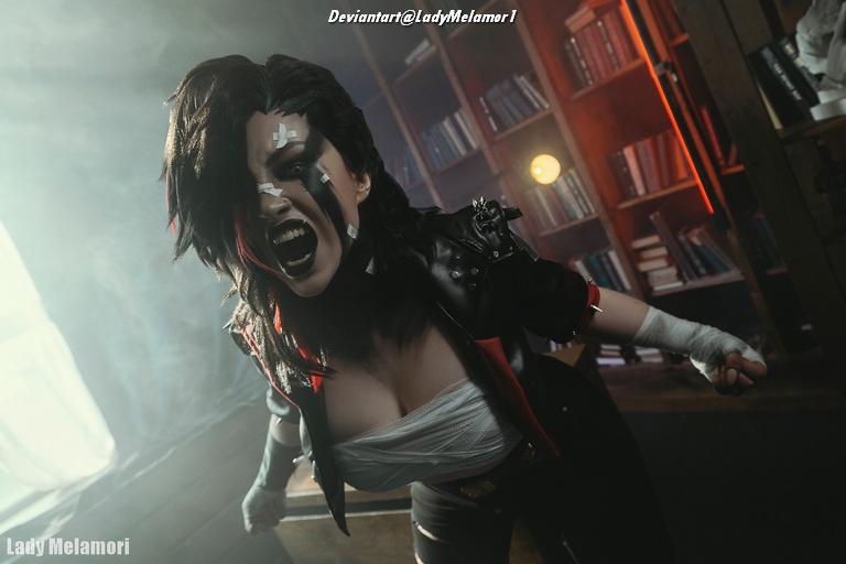 A woman in a dramatic cosplay outfit with black and red hair, wearing a black jacket and shouting fiercely, stands against a backdrop of bookshelves with warm lighting.