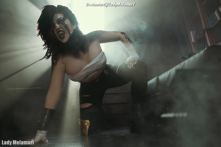 A woman in a dramatic pose, wearing a costume with black pants and partial bandaging, surrounded by fog and soft light, evoking a powerful character depiction.