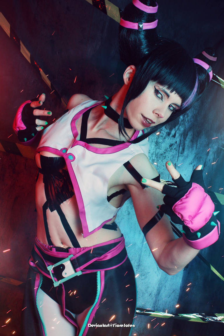 A person in a colorful, stylized outfit poses confidently in a dramatic setting with vibrant lighting effects.