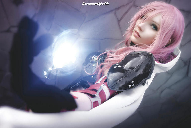 A character with long pink hair wearing a futuristic outfit is extending a hand, showcasing a magical glow in front of them. The background features a textured, abstract structure.