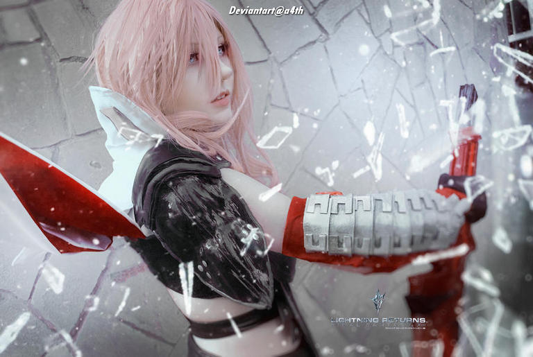 A close-up of a person in a detailed cosplay outfit resembling a character with pink hair, holding a weapon and surrounded by shattered glass.
