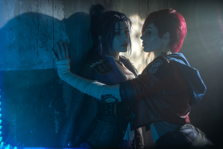 Two female characters in a dramatic pose against a textured wall, with moody lighting highlighting their expressions and outfits.