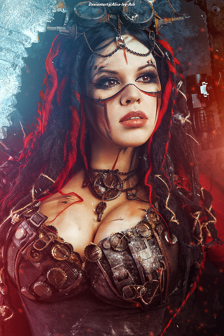 A woman with dark hair and styled dreadlocks, wearing a steampunk-inspired outfit adorned with metal accessories and straps, gazes intently at the camera. The background features industrial elements, enhancing the overall dramatic aesthetic.