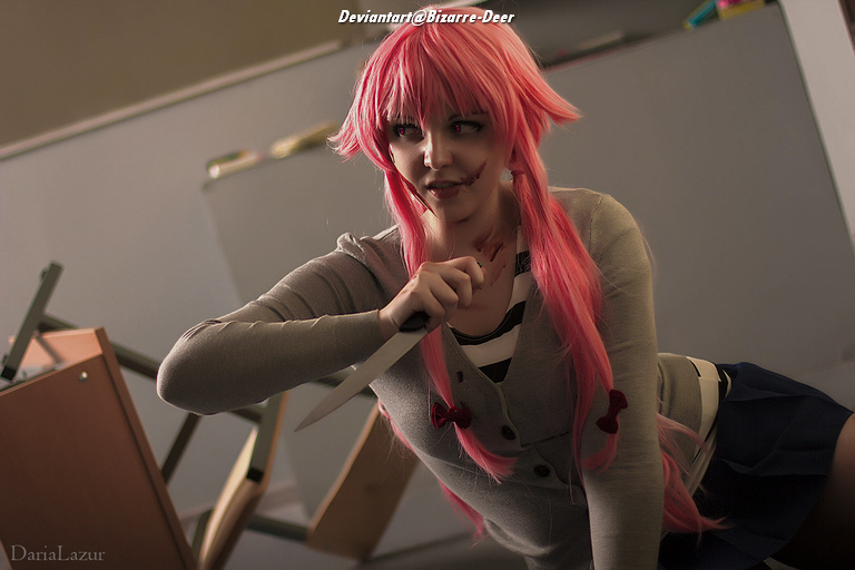 A person with long pink hair in a school uniform holding a knife, with scars on their face, posed in a dramatic manner against a backdrop of scattered objects.