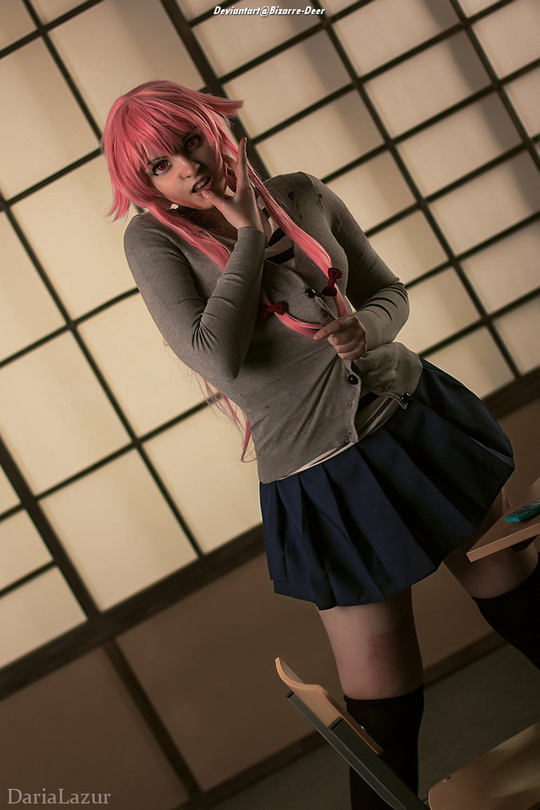 A character in a classroom setting, wearing a gray cardigan and a navy blue skirt, with long pink hair and a playful pose.