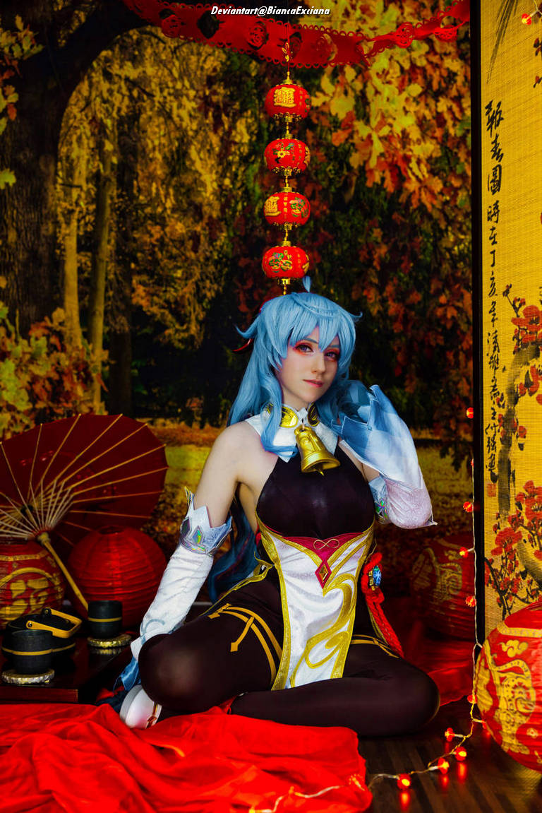Cosplayer sitting in a vibrant setting with red lanterns, surrounded by autumn foliage and traditional decorations.