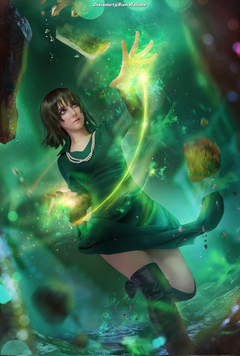 A magical scene featuring a woman with short hair in a green dress, casting a spell with an outstretched hand amidst swirling green lights and floating debris.