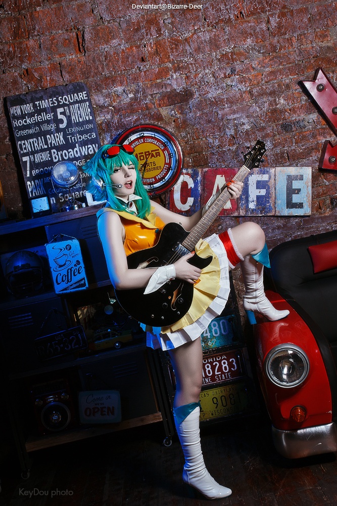 A person dressed in a colorful costume playing an electric guitar in a retro-themed setting with vintage signs and decorations.
