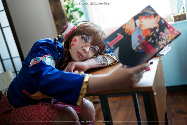 A person dressed in a colorful outfit with headphones, posing with a comic book in a cozy indoor setting.