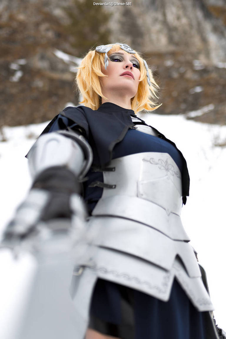 A person dressed in a medieval-style costume with silver armor and blonde hair, posed dramatically against a snowy landscape.