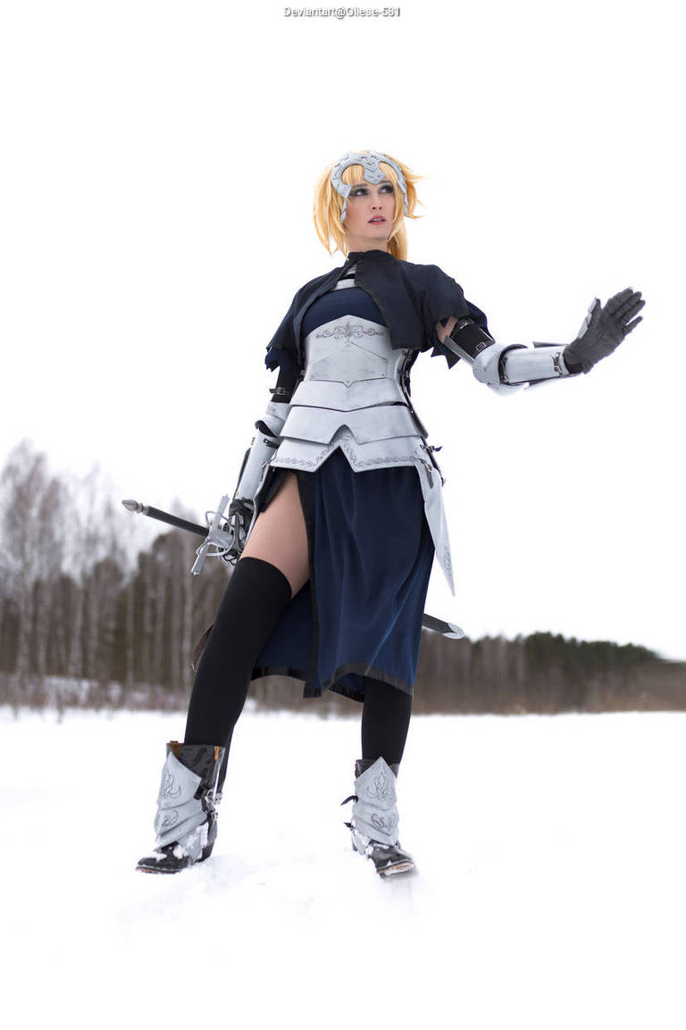 A person in an elaborate cosplay costume resembling a fantasy warrior, standing in a snowy landscape with an outstretched hand.