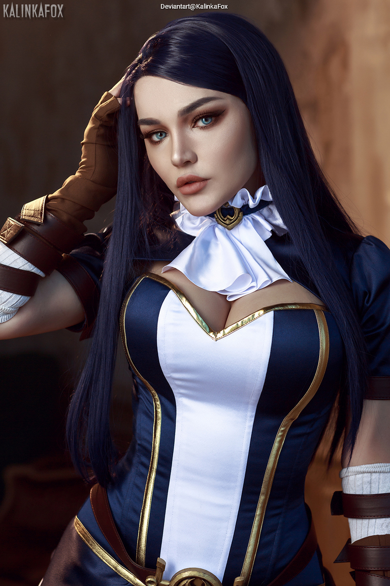 Close-up portrait of a person in a dark blue and white outfit with a high collar and long black hair, striking a confident pose.