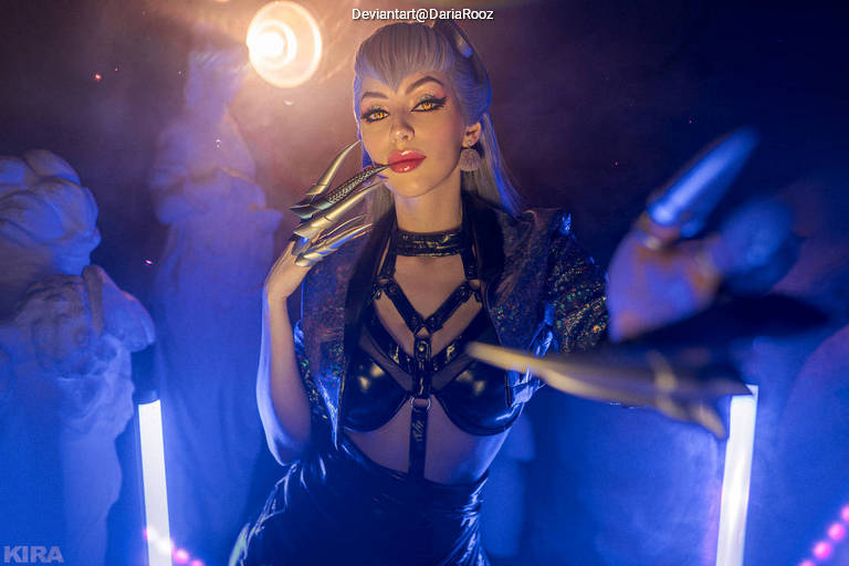 A model in a dramatic pose wearing a stylish leather outfit with bold makeup, surrounded by colorful lighting and artistic sculptures.