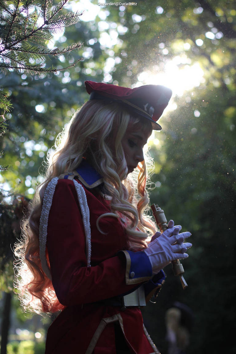 A person dressed in a red military-style outfit with a matching hat, holding a flute, surrounded by greenery and soft sunlight filtering through the trees.