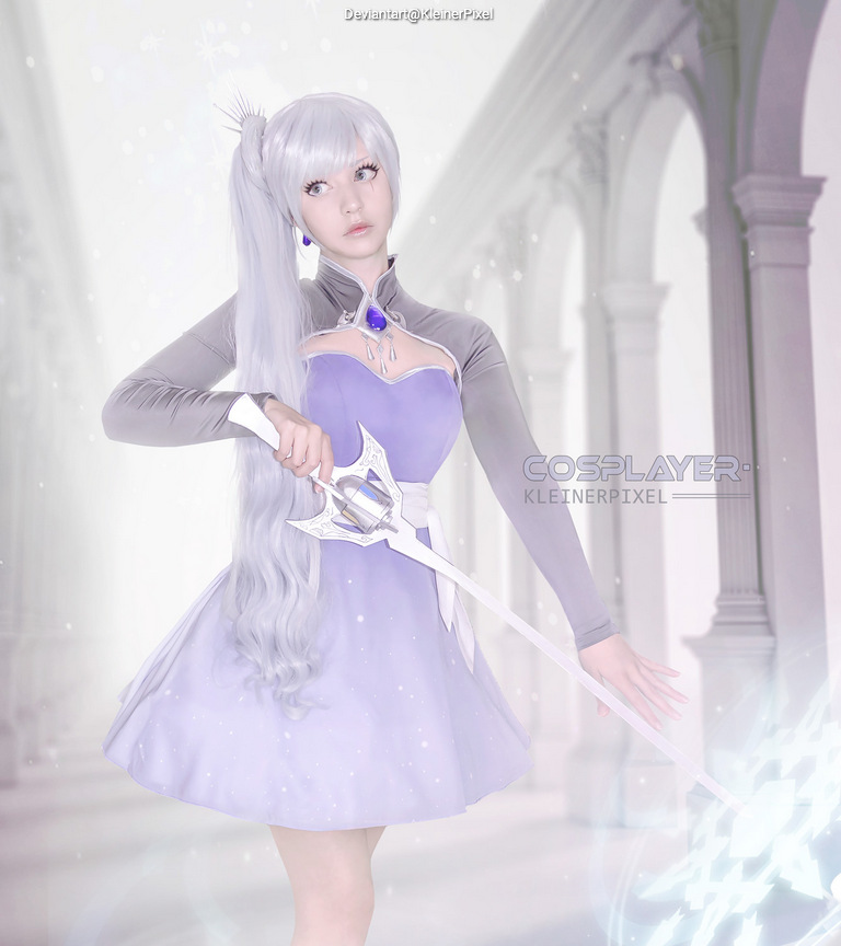 A cosplayer dressed as a character, with long silver hair and a purple dress, posing with a sword in a bright, elegant setting.