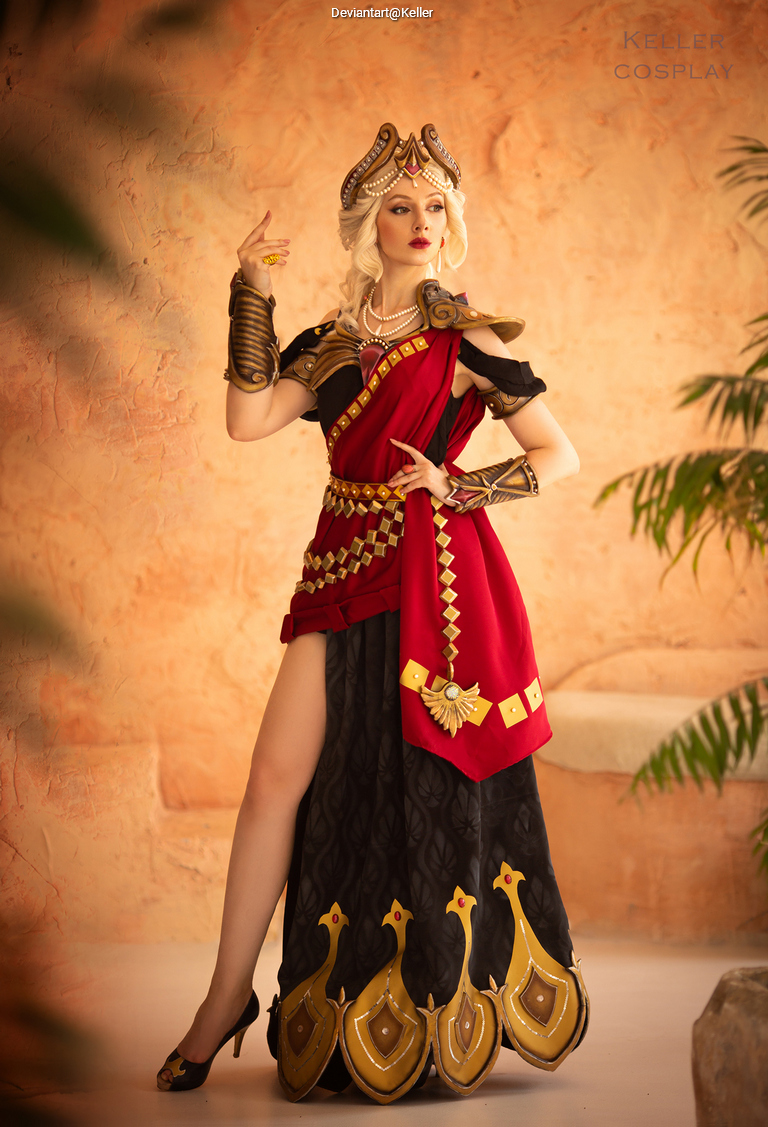 A woman in an elaborate red and black costume with golden accessories, posing confidently with an ornate headpiece and a decorated bodice set against a textured background.