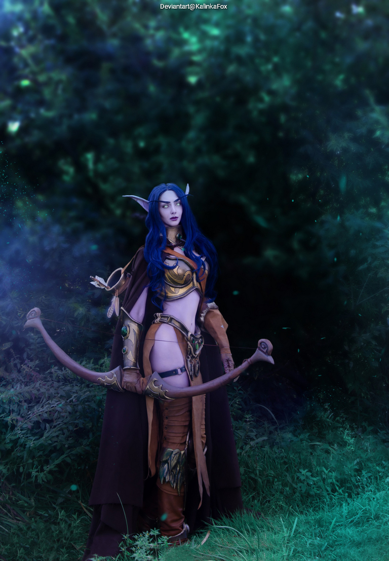 A character dressed in elaborate fantasy armor with a bow, standing in a forest setting with a mystical atmosphere.