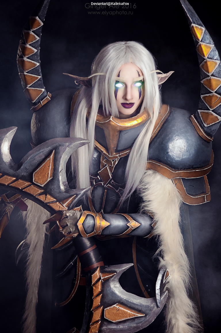 A person in elaborate fantasy armor with long white hair, wielding a large weapon, in a dramatic, atmospheric setting.