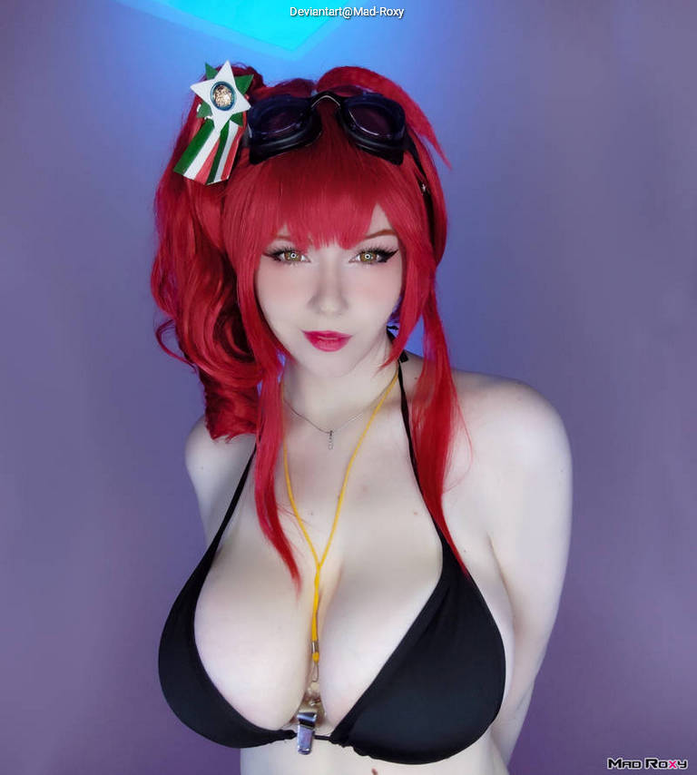 A person with red hair styled in pigtails, wearing black swimwear and goggles, poses against a purple background.