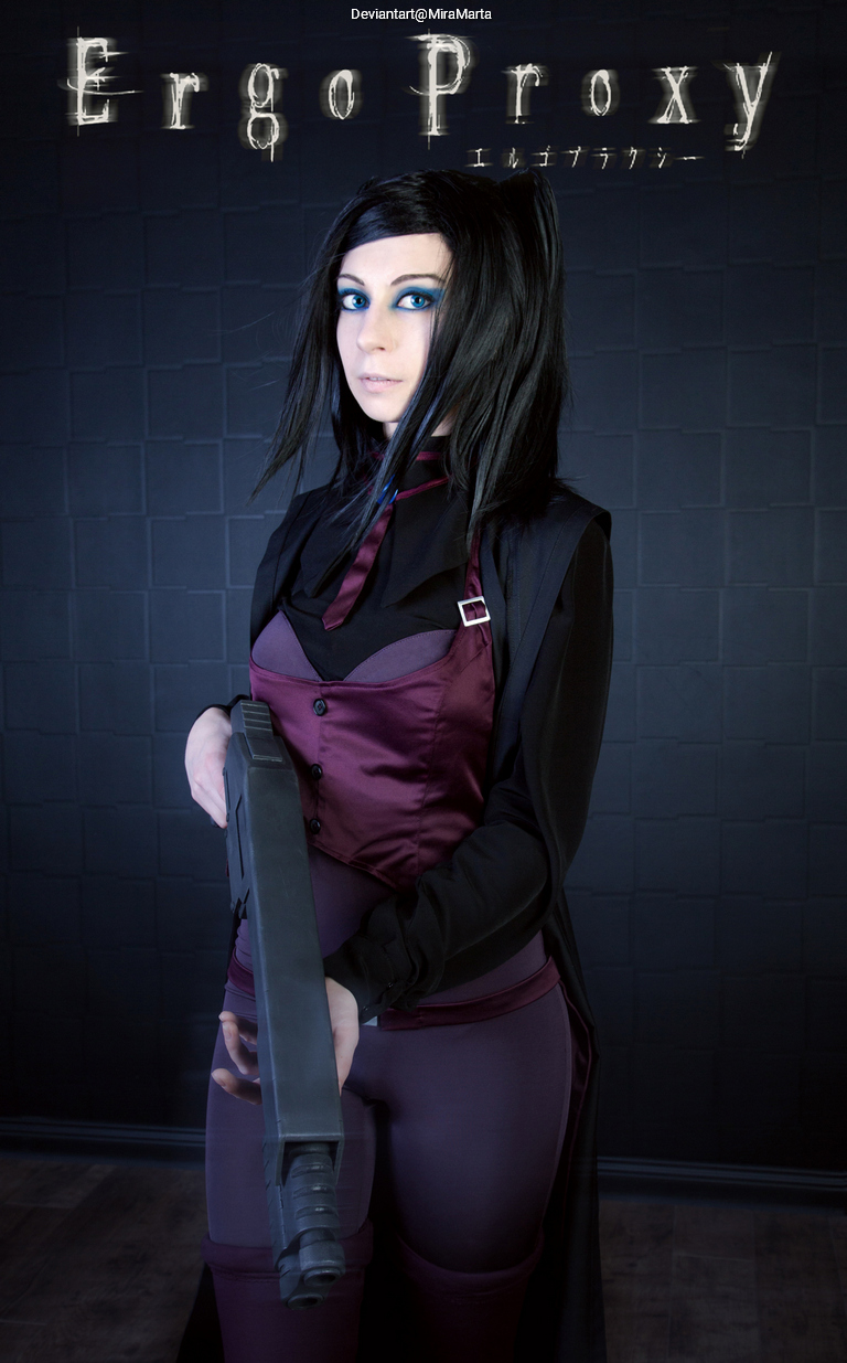A person dressed as a character from the anime 'Ergo Proxy,' holding a gun, with dramatic makeup and a dark outfit, set against a simple black background.