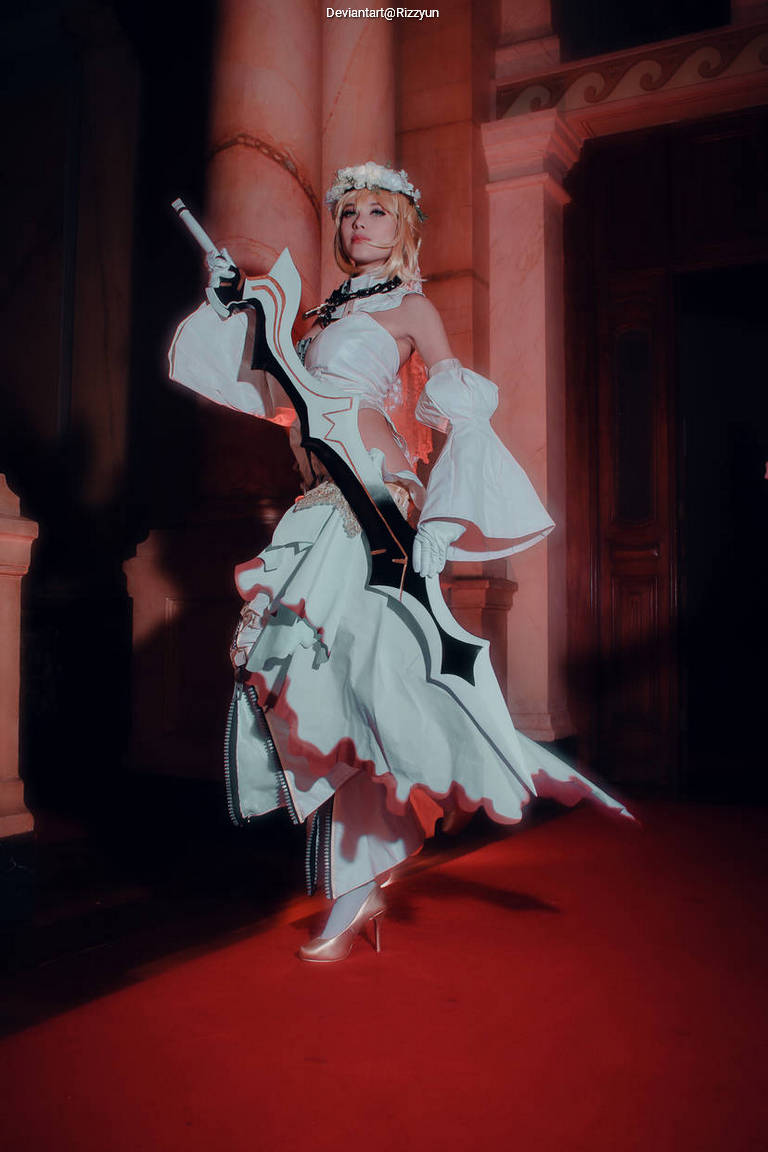 A person posing in a flowing white costume with black details and high heels, holding a sword, set against an elegant background with ornate pillars.