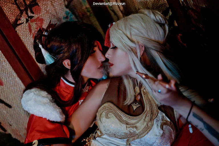 Two cosplayers in close proximity, portraying characters with elaborate costumes and hairstyles, set against a textured background.