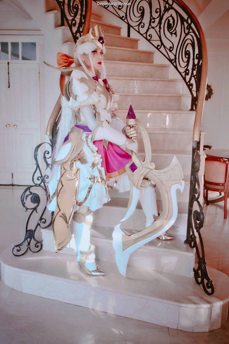 A cosplayer dressed as a character in elaborate armor, holding a weapon, standing on a staircase with decorative railing.