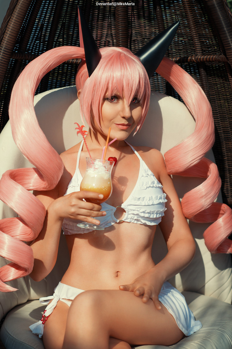 A young woman with long pink hair styled in pigtails and dark horns, wearing a white bikini, sitting on a chair and holding a tropical drink.