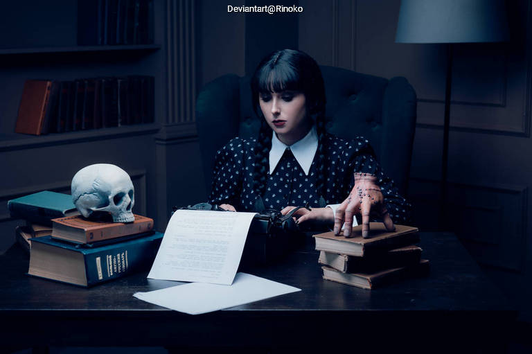A woman sits at a desk surrounded by books and a skull, typing on a vintage typewriter. The room is dimly lit, and she has long dark hair and is wearing a polka dot dress with a white collar.