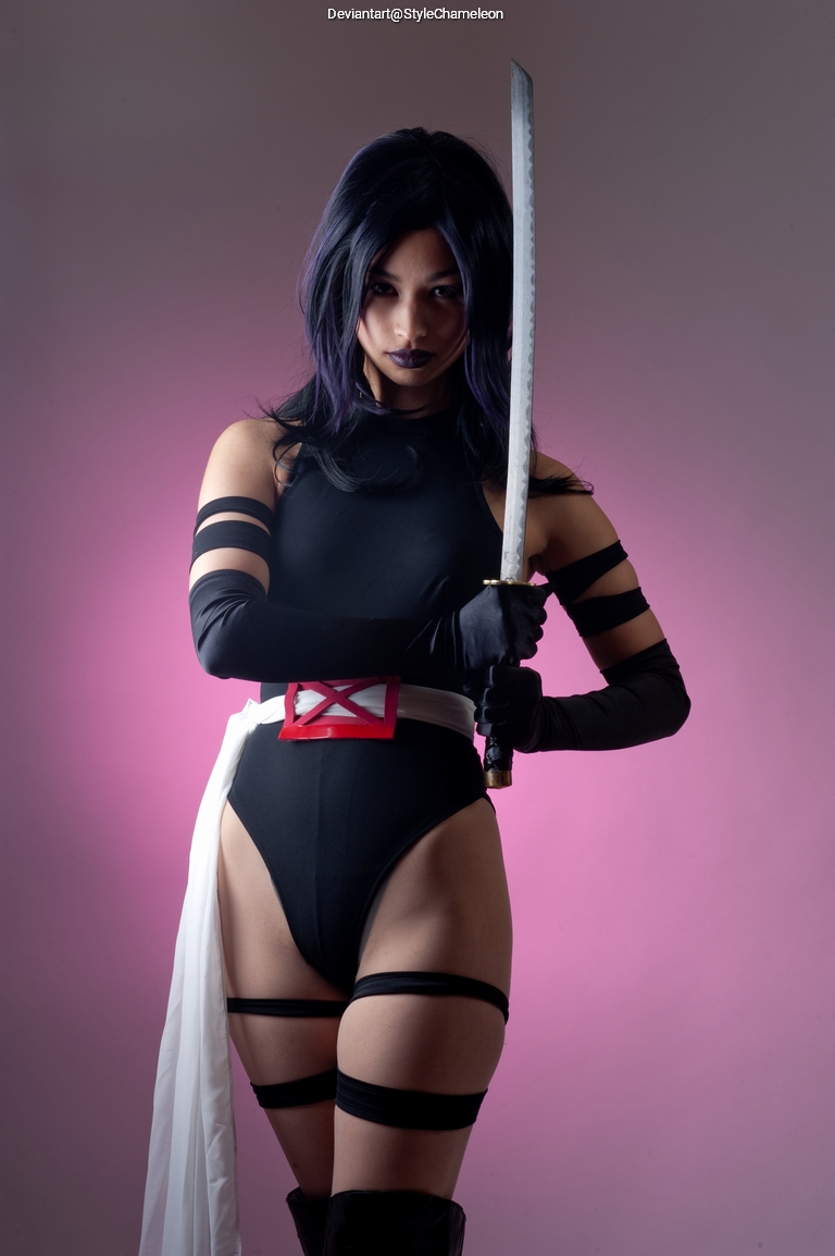 A figure dressed in a black bodysuit with gloves and headband, holding a katana. The background is a gradient of pink colors.