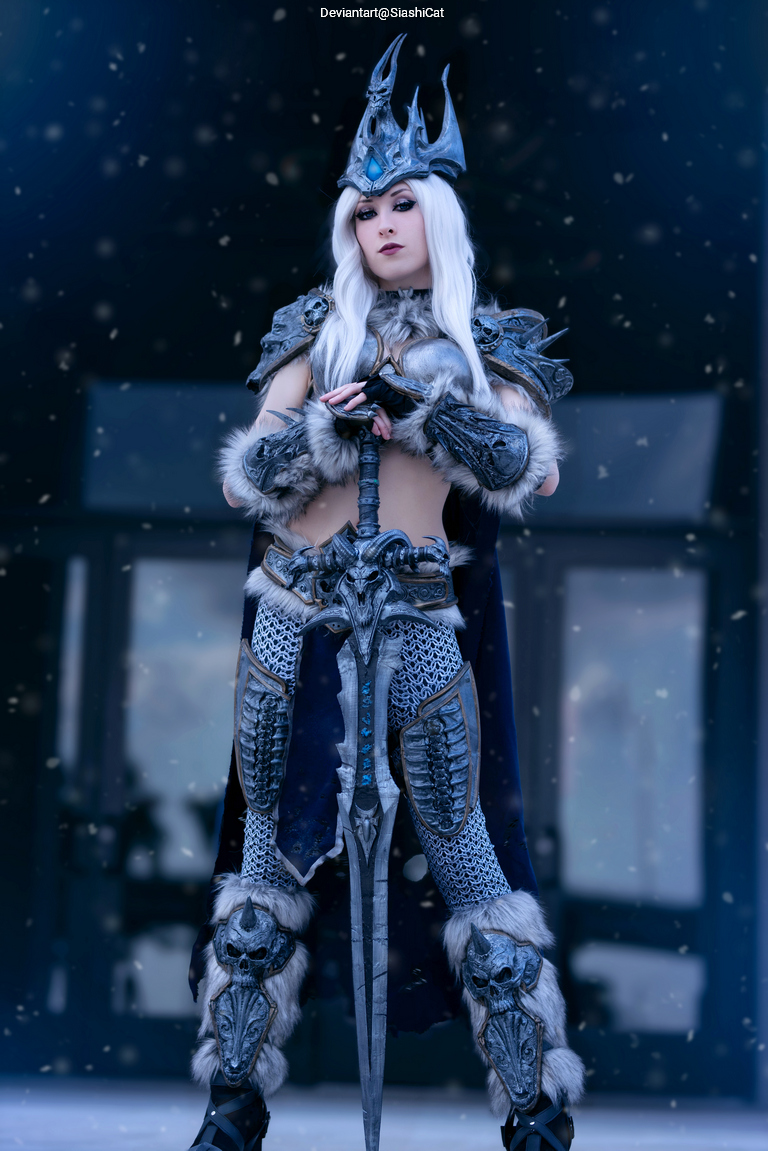 A person in detailed costume resembling a character from a fantasy game, featuring ornate armor and a crown, standing in a snowy environment.