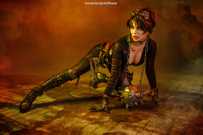 A character in a steampunk-inspired outfit, crouching on the floor with a chain and spiked ball, set in a dramatic, smoky environment with orange and brown hues.
