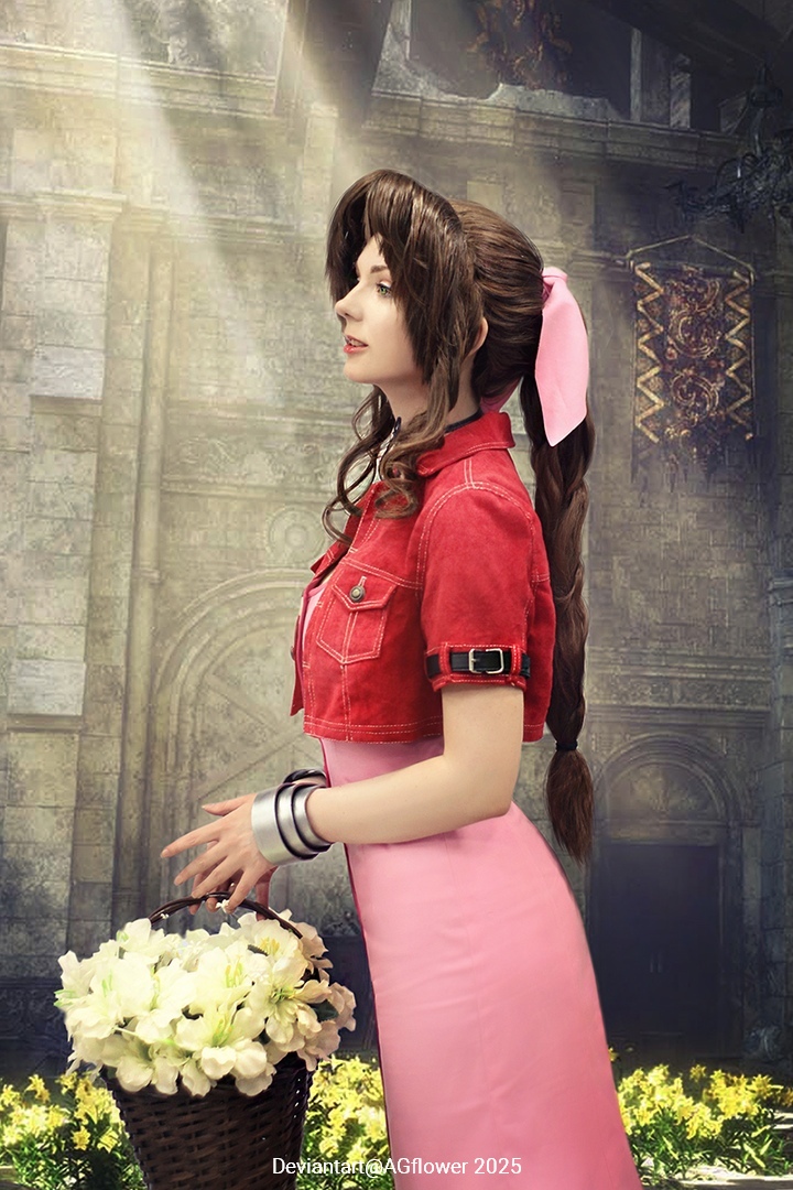 A woman with long brown hair and a pink ribbon, wearing a red jacket and a pink dress, holds a basket of white flowers. The background features an ornate, soft-lit interior with stone walls.