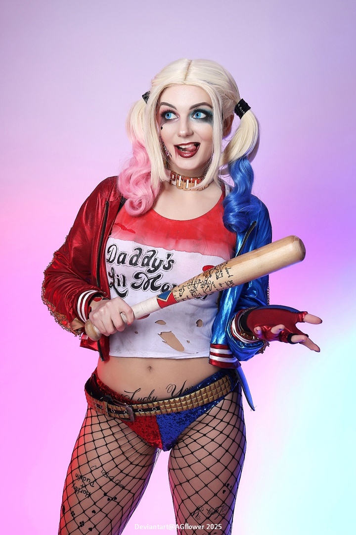 A cosplayer dressed as Harley Quinn, featuring multicolored hair, a red and blue outfit, fishnet stockings, and holding a baseball bat. The background has a gradient of pink and purple hues.