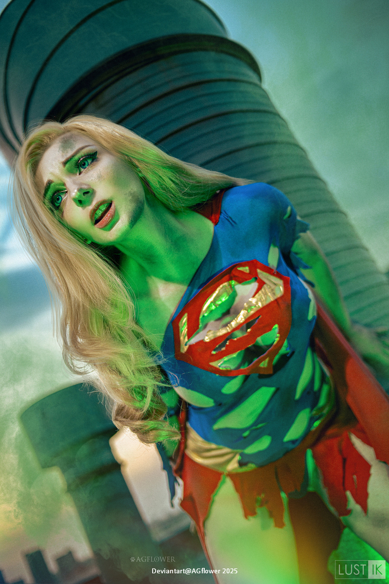 A woman dressed as a superhero with a torn costume, depicting a distressed expression against an industrial background with green smoke.